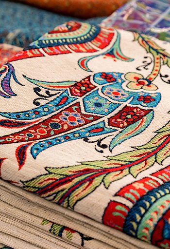 Close-up woven tapestry vintage decor on a Turkish bazaar. Traditional Turkey rugs oriental craft and decor of interior. Selective focus