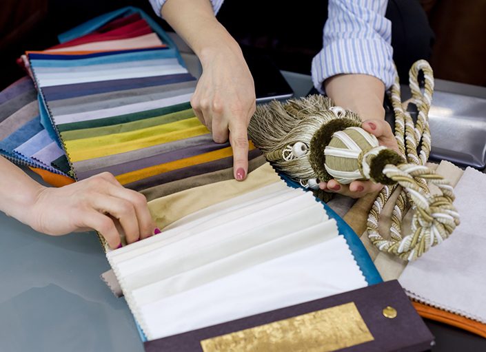 Interior designer shows samples of interior fabrics. Selection fabrics for curtains, bedspreads, pillows. Decorating shop